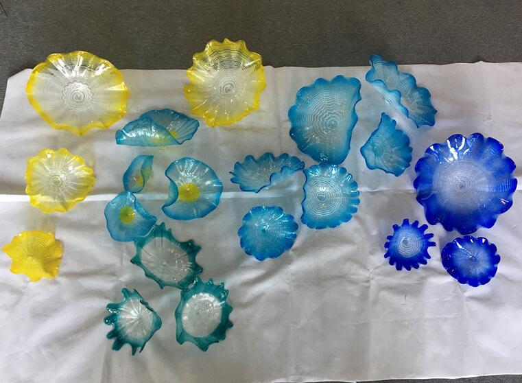Artistic Murano glass wall lamps with scalloped edges, featuring blue and yellow floral designs for decorative lighting