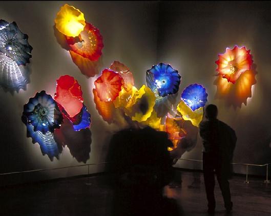 Contemporary handcrafted blown glass lamps and decorative plates featuring vibrant Murano floral designs for wall art