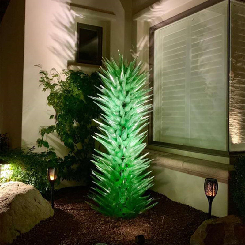 Custom handcrafted blown glass lamps for indoor decor, featuring green glass art floor lamps and garden sculptures of flowers and trees