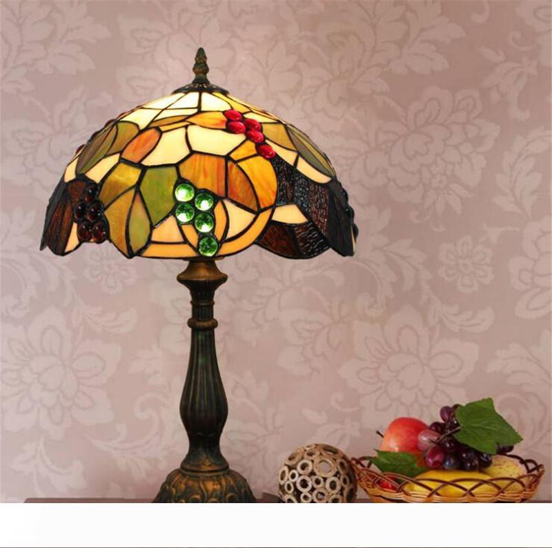 Grape-patterned vintage Tiffany table lamps with stained glass shades, ideal for rustic bar or restaurant lighting