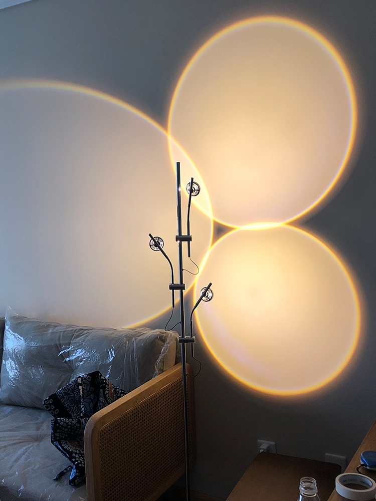 Minimalist Italian-inspired LED floor lamp with creative light and shadow effects for sofa areas, featuring sunset projection art