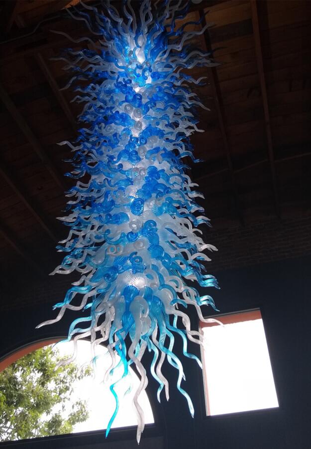 Modern pendant lamps featuring large crystal chandeliers with blue and white borosilicate glass, LED lighting, and chain suspension for high ceilings