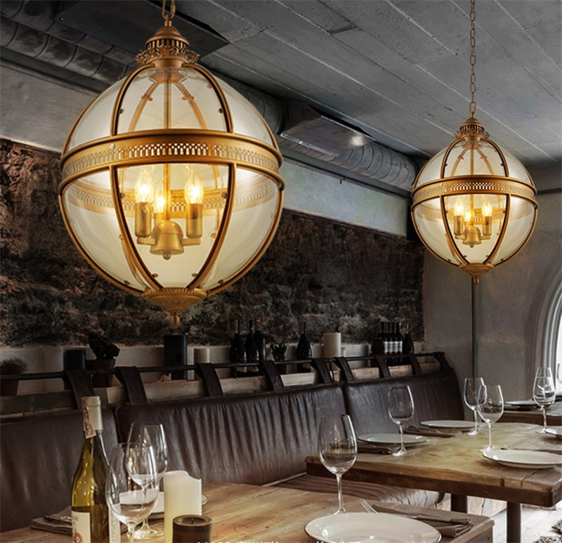 Vintage industrial-style pendant light with wrought iron frame and glass shade, perfect for kitchen, dining, or bar areas